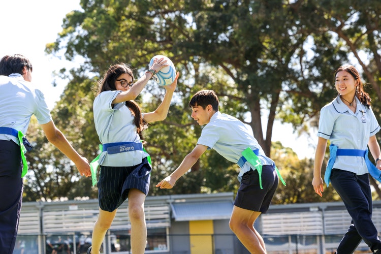 An image of a student making at break playing oztag whilst students try and tag her,