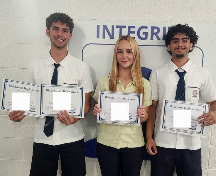 An image of three students proudly holding their achievers certificates.