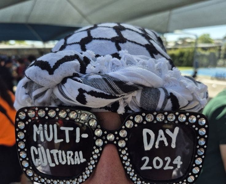 An Image of a student wearing sunglasses with gems and writing on the lenses saying Multicultural day 204.