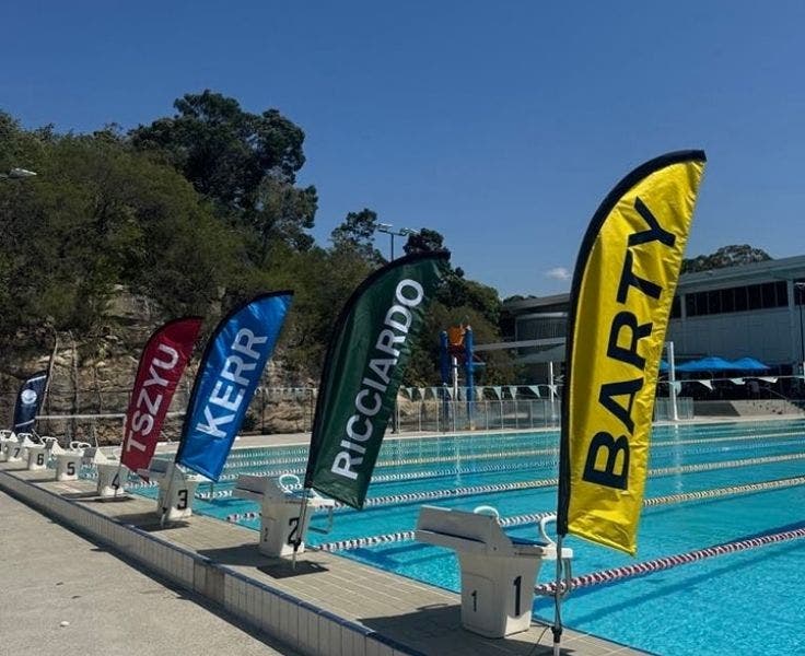 An image of our 4 groups, Barty, Ricciardo, Kerr and Tszyu flags by the side of the swimming pool.