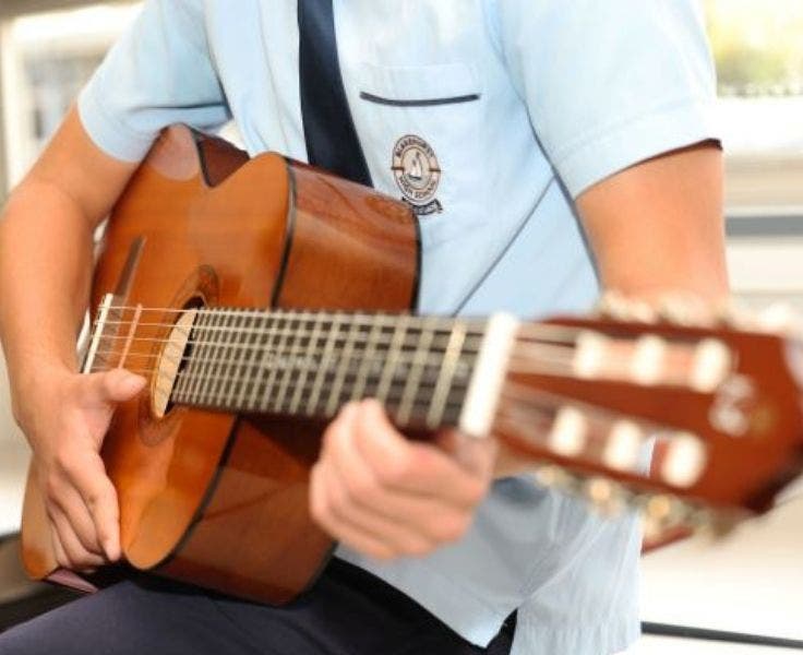 An close up image of a student playing the guitar.