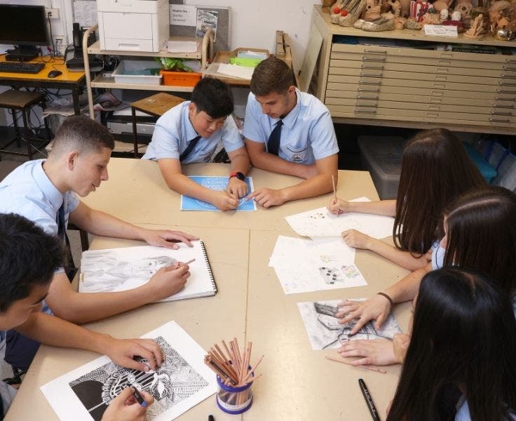 An image of students in the art room drawing at the art table.
