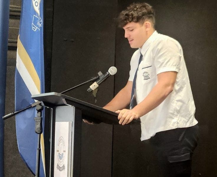 An image of a student addressing the crowd at a lectern.