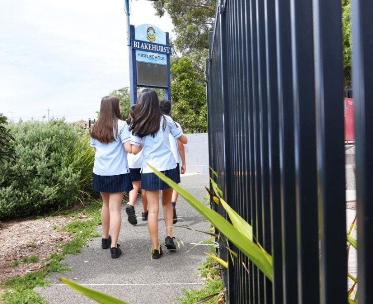 An image of students walking out of the school gates on their way to an excursion.